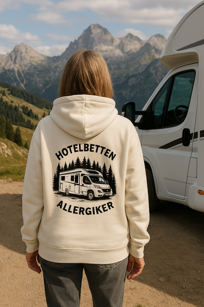 Frau trägt weißen Zipper Hoodie mit Aufdruck „Hotelbetten Allergiker“ und Camping-Motiv vor Bergkulisse – ideal für Outdoor- und Vanlife-Fans von Camper4Love