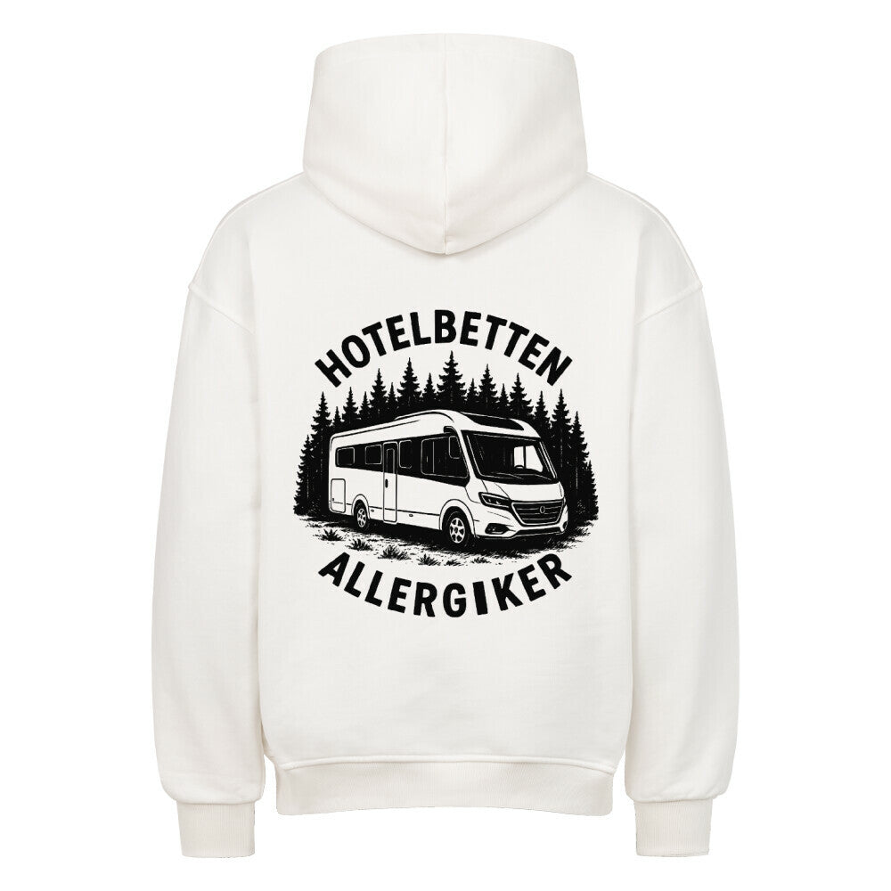 Mann steht vor einem Bergsee und trägt einen orangen Hoodie von Camper4Love mit dem Aufdruck „Hotelbetten Allergiker“ und Van-Motiv – ideal für Outdoor-Fans und Vanlife-Liebhaber.