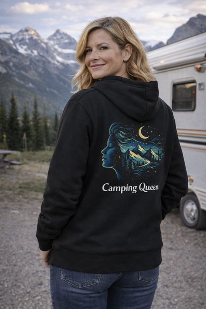 Frau mittleren Alters trägt einen schwarzen „Camping Queen“ Hoodie mit Rückenprint und steht vor einem Wohnwagen in den Bergen – stylisches Camper4Love Outdoor-Mockup für Camping-Fans.
